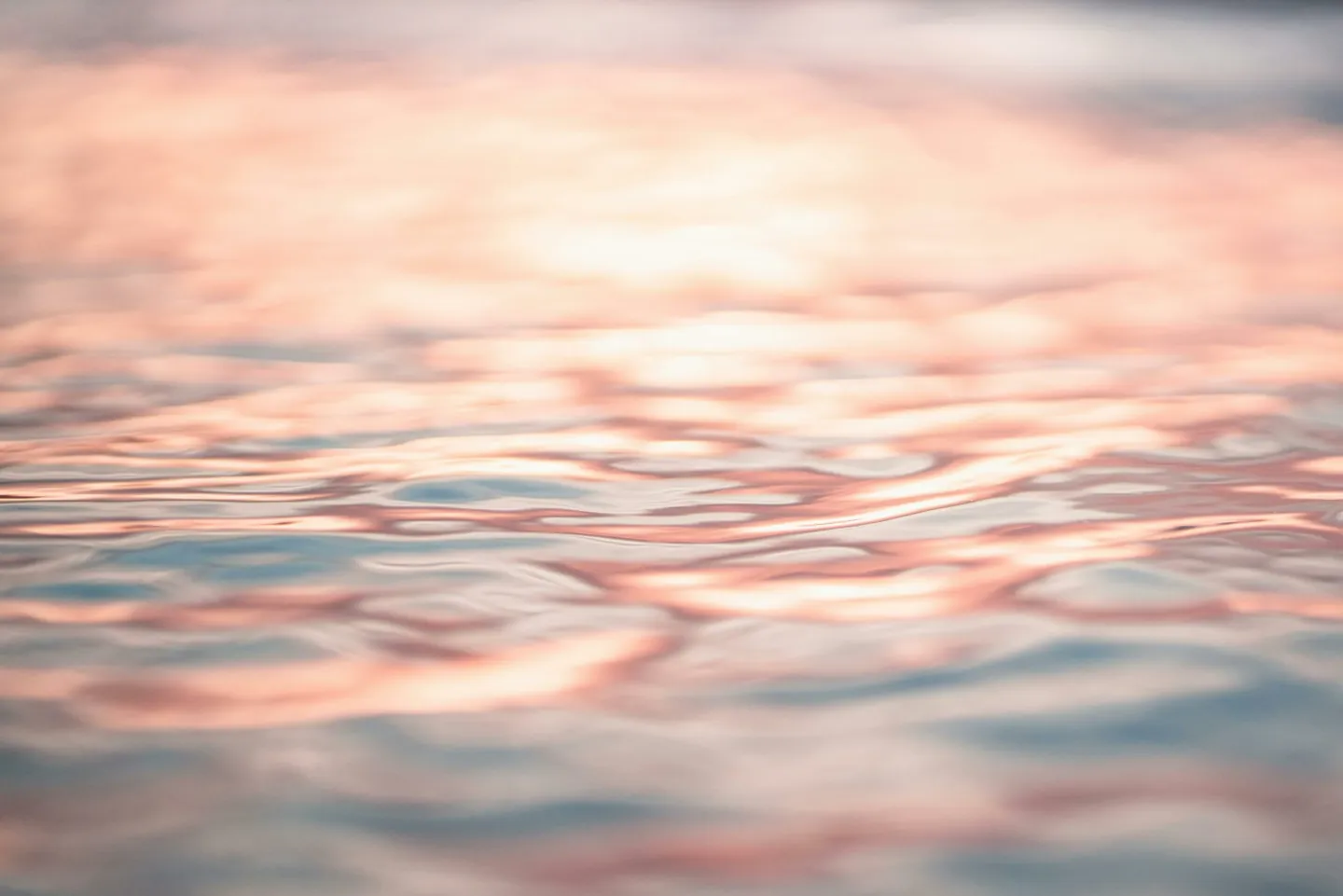 Photo d'une surface d'eau avec les lumières du soleil couchant. L'hypnose aide à apaiser la douleur. Hypnose. Hypnose ericksonienne.