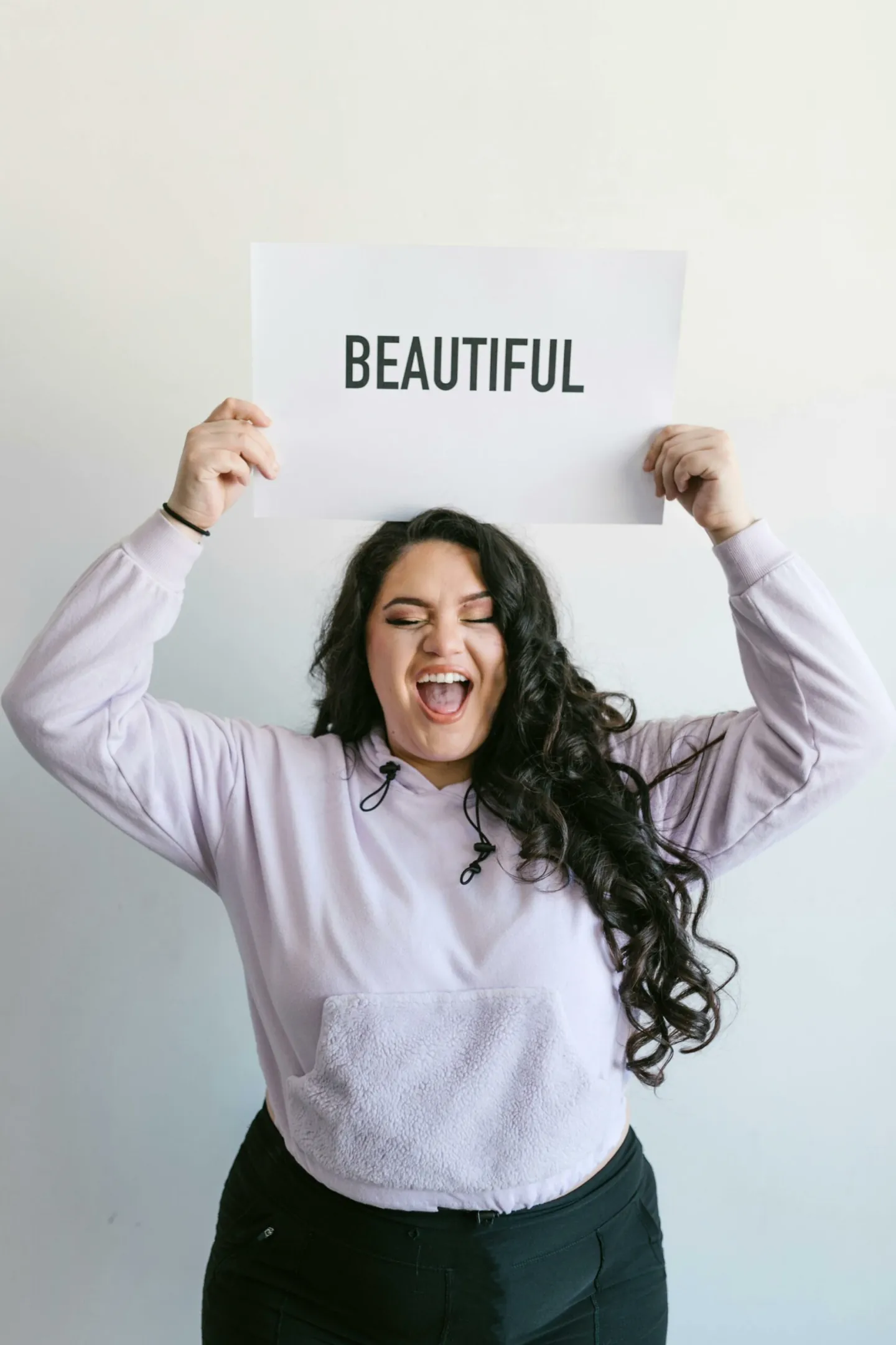 Une femme tient fièrement une pancarte "beautiful" au dessus de sa tête - Améliorer son estime de soi: mode d'emploi - coaching de vie - hypnose à Nantes - Sylvie Rauwel - Nantes