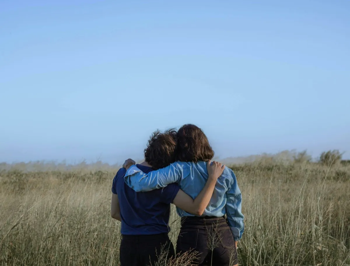 Deux femmes, de dos, dans un champ, se tiennent par les épaules - Image de soi - Améliorer son estime de soi