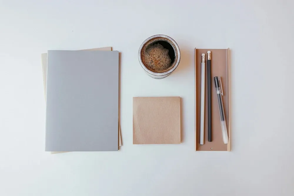 Feuilles de papier, crayons et tasse de café